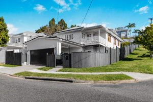 Queenslander renovation Bardon Brisbane – fully restored home exterior with modern garage and fencing.